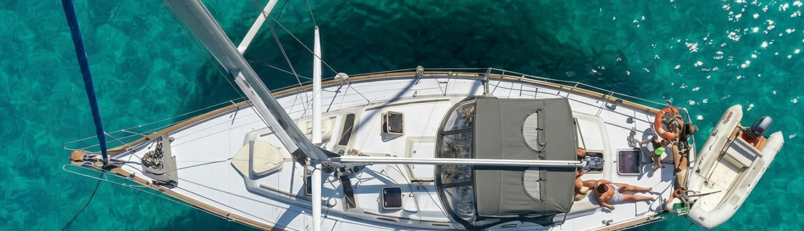 El velero Paradise fondeado en una cala de aguas turquesas en Formentera, ideal para un charter consciente.